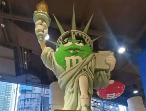 a statue of the Sttaue of LIberty with an giant plastic M and M as the face