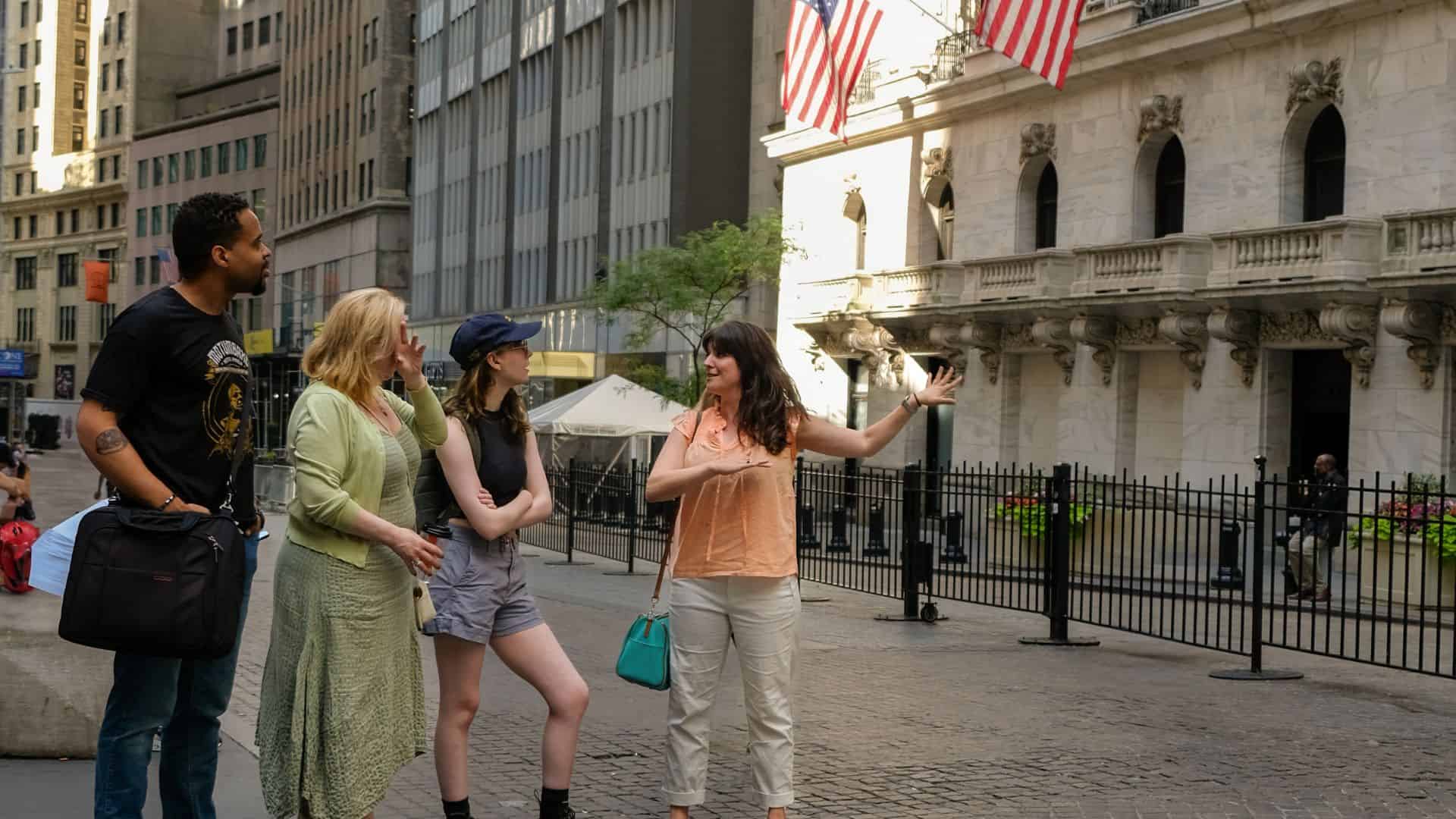 Tour guide leading visitors outside the New York Stock Exchange in Lower Manhattan.
