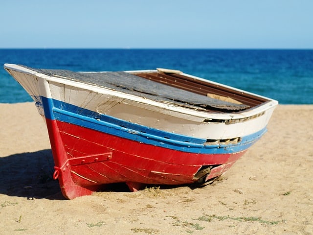 An old boat on a beach in Barcelona. Image source: Pixabay user Tibor Janosi Mozes.