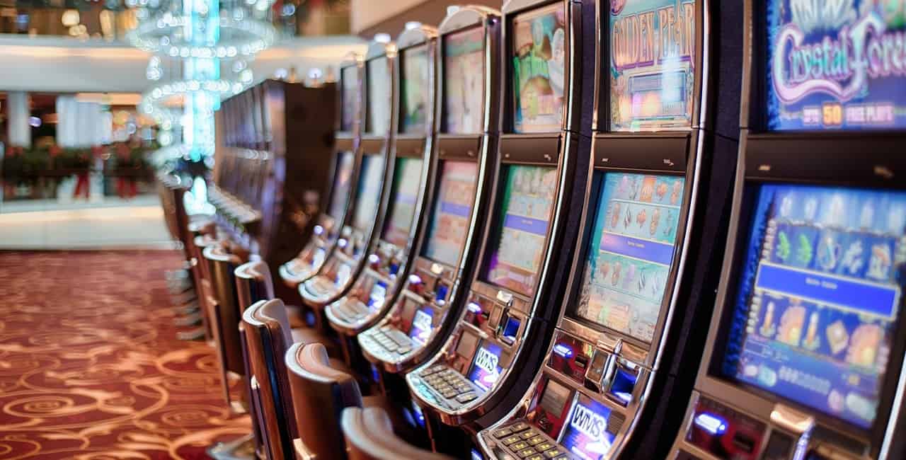 A row of slot machines at a casino. Image source: Pixabay user stokpic.
