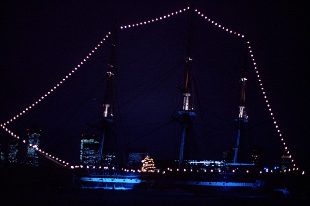 A view of the sail frigate USS CONSTITUTION (IX-21) decorated with lights and a Christmas tree for the holiday by The U.S. National Archives