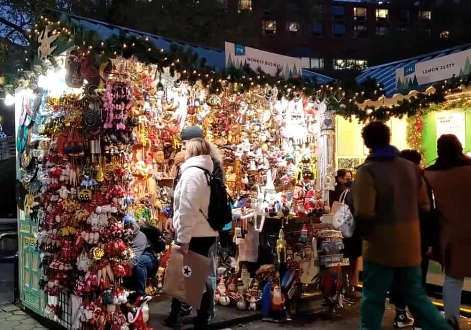 a vendor at the Christmas Market at Union Square with a customer browsing